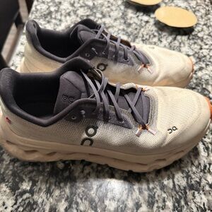 On Running Cream and Black Athletic Shoes